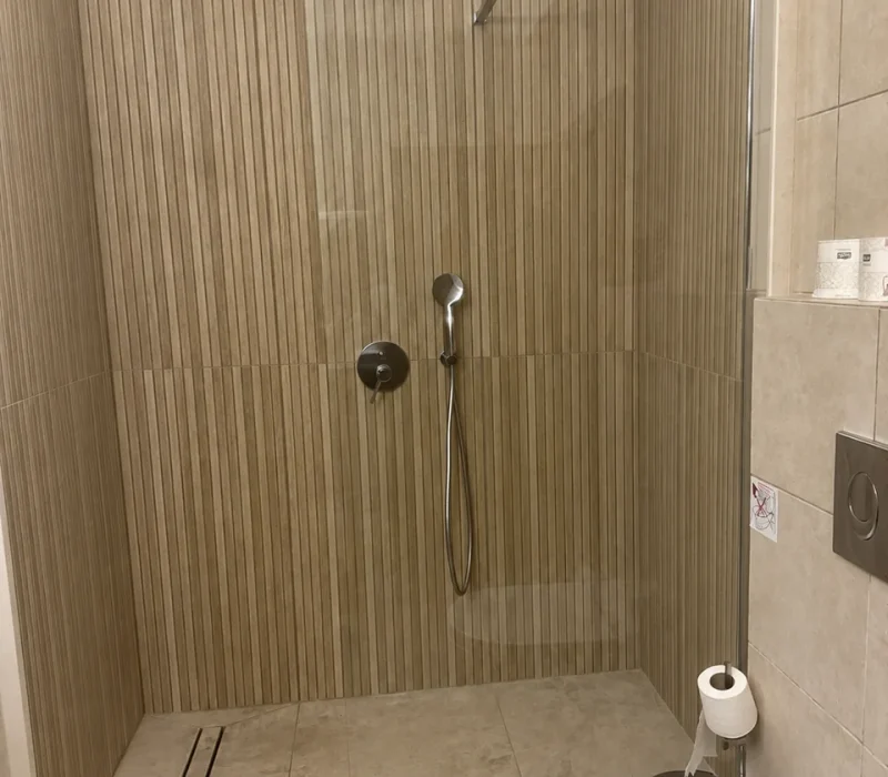 Thalassa suite walk-in shower with fluted beige tiles and glass screen