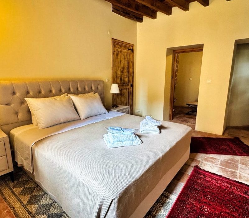 Iris Junior Suite bedroom with windows and a red rug