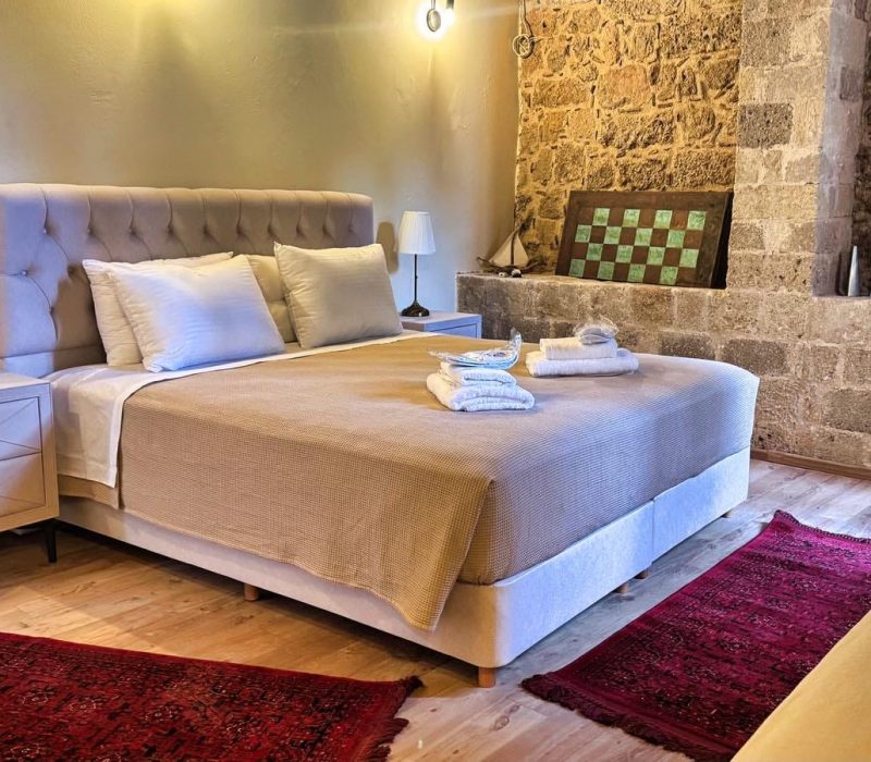 Daphne Junior Suite bed beside an exposed stone wall
